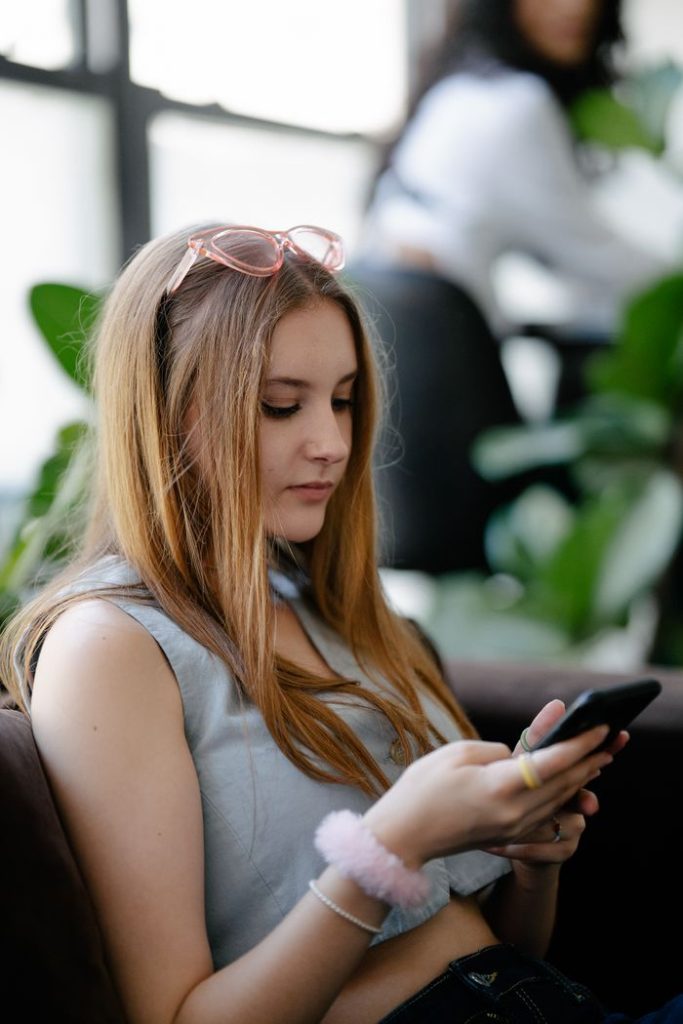 woman-with-brown-hair-holding-cellphone-13929450